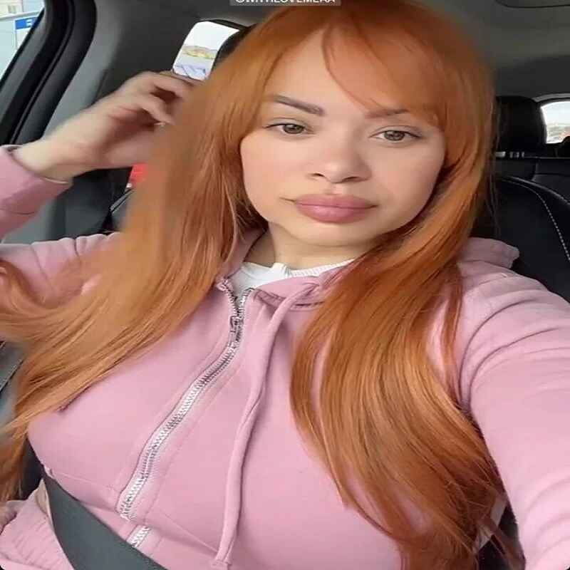 Charina Almanzar sitting in a car, wearing a pink hoodie, confidently showcasing her natural beauty and relaxed style.